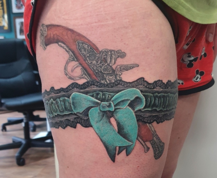 garter tattoo with a gun